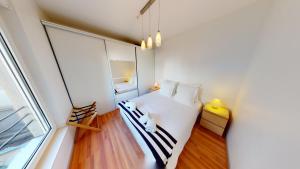 ein kleines Schlafzimmer mit einem weißen Bett und einem Fenster in der Unterkunft Le 23 - Strasbourg in Straßburg