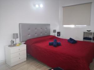 una camera da letto con un letto rosso e due cuscini blu sopra di Eldorado Casa Gi a Playa de las Americas Altre 13 foto