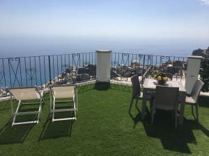 einen Tisch und Stühle auf einem Balkon mit Aussicht in der Unterkunft Casa Roberta in Positano