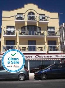 una señal frente a un edificio con coches aparcados delante en Hotel Oceano, en Nazaré