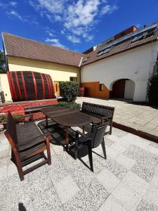 eine Terrasse mit 2 Bänken, einem Tisch und Stühlen in der Unterkunft Penzion Fontána in Mikulov