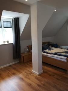 an attic bedroom with a bed and a window at Ferienwohnung Telemann Stadtmitte in Eisenach