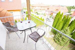 a balcony with a table and chairs and a view of a street at Relax Apartment House in Zalakaros