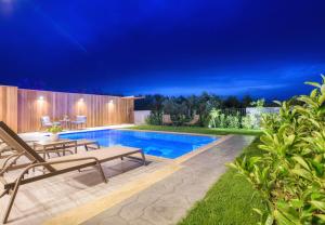 a backyard with a pool with a table and chairs at AKEA VILLAS in Tragaki