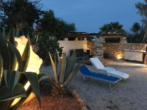 un patio con 2 sedie a sdraio e un camino di Villa Respiro a Lampedusa