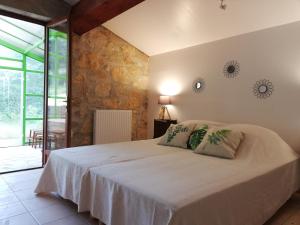 1 dormitorio con 1 cama blanca grande y 2 almohadas en Domaine des Goudis en Bouisse