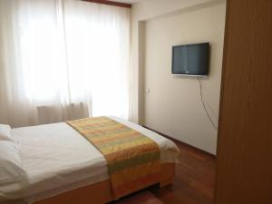 ママイアにあるCris Black Seaのベッドルーム1室(ベッド1台、壁掛けテレビ付)