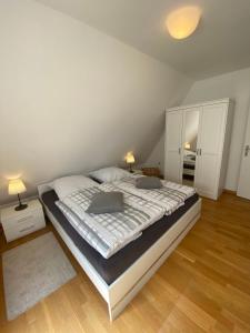 a bedroom with a large bed with two pillows at Gemütliche Ferienwohnung Nesco mit eingezäunten Garten in Aurich