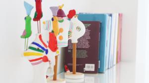 a toy chicken on a shelf next to a book at B&B Battisti59 in Vieste
