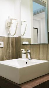 y baño con lavabo blanco y espejo. en B&B Battisti59, en Vieste