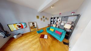 a living room with a blue couch and a television at Loft des Arcades *** – City center in Strasbourg