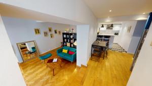 a living room with a blue couch and a table at Loft des Arcades *** – City center in Strasbourg