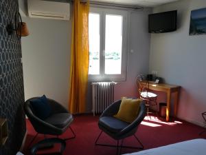 a room with two chairs and a window at Le Régence in Arles
