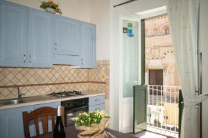 una cocina con armarios azules y una mesa con fregadero en Palazzo Tranfo Al Duomo Accommodation, en Tropea