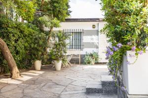a patio with plants and flowers in front of a building at Pochi Passi dal Mare in San Bartolomeo al Mare