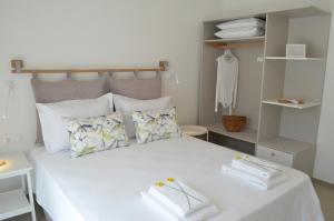 une chambre avec un lit blanc avec des serviettes dessus dans l'établissement Casa MaLu Boutique Apartments - No 1, à Gouviá