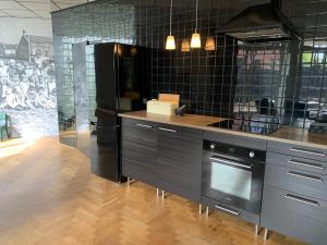 a kitchen with a counter with a stove and a refrigerator at De Oude Kleuterschool in Zoelen