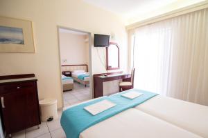 Postel nebo postele na pokoji v ubytování Dionisos Hotel