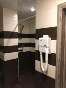 baño con ducha con rayas blancas y negras en Aron Hotel, en Kazán