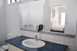uma casa de banho com um lavatório e um espelho em Eight Spence em Warrnambool