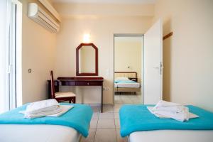 1 Schlafzimmer mit 2 Betten, einem Waschtisch und einem Spiegel in der Unterkunft Dionisos Hotel in Mitikas