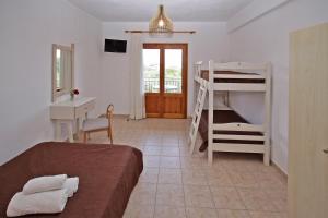a bedroom with a bed and a desk and bunk beds at Studios Stella Vourvourou in Vourvourou