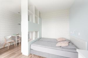 Dormitorio pequeño con cama y mesa en Studio w parku nad zatoką, en Puck