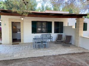 un patio con tavolo e sedie di fronte a una casa di Appartamenti in villa Senia a Favignana