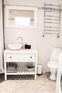 ハープサルにあるPõllupesaの白いバスルーム(洗面台、トイレ付)