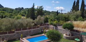 a swimming pool in a garden with trees at Villa Zoi in Pelekas