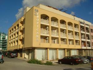 a large building with cars parked in a parking lot at ТРОПИКАНА in Primorsko
