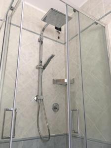 ナーゴ・トルボレにあるPanoramaのシャワーヘッド付きのガラスドアが備わるシャワールームです。