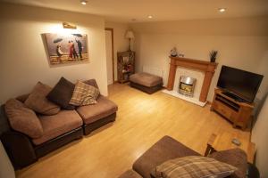 a living room with a couch and a fireplace at Atholl Cottage in Nairn