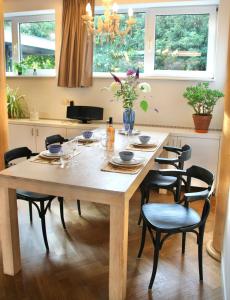 a wooden table in a kitchen with chairs around it at De Oude Kleuterschool in Zoelen