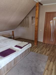 a room with a bed and a wooden floor at Номер в приватному будинку in Morshin