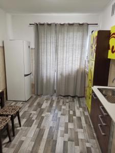 a kitchen with a white refrigerator and a floor at Номер в приватному будинку in Morshin