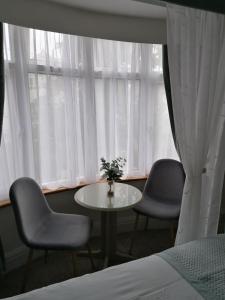 a room with two chairs and a table in front of a window at Blue Waters Lodge in Paignton