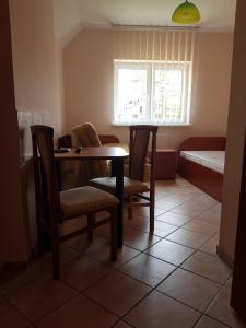 a small room with a table and chairs and a bed at Zacisze Konopnickiej in Pobierowo