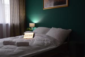 a green bedroom with a bed with a book on it at Apartament Centrum in Szklarska Poręba