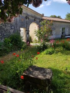 einen Garten mit einer Steinbank vor einem Gebäude in der Unterkunft Domaine De Chantemerle B'nB in Marsac