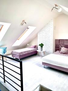 een slaapkamer op zolder met 2 bedden en een dakraam bij Apartament Bursztynek Jantar Park in Jantar