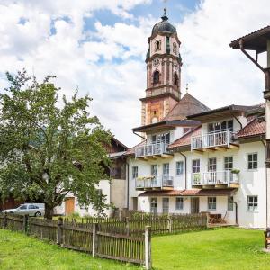 um edifício com uma torre de relógio em cima em Exklusive Ferienwohnung in der historischen Ballenhausgasse em Mittenwald