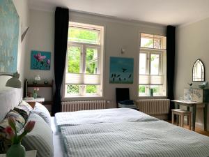 a bedroom with two beds and two windows at Waldmühle in Schleswig