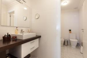 een witte badkamer met een wastafel en een toilet bij Lisbon City Center Baixa in Lissabon +31 foto's