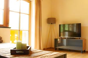 ein Wohnzimmer mit einem Flachbild-TV auf einem Entertainment-Center in der Unterkunft Landhaus Mair in Scharnitz