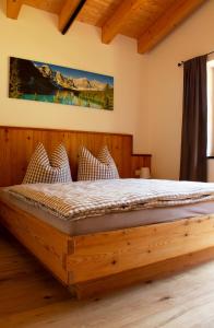 een slaapkamer met een houten bed in een kamer bij Landhaus Mair in Scharnitz