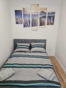 um quarto com uma cama com quatro pinturas na parede em Apartament De Luxe Emily em Jelenia Góra