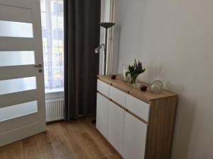 um quarto com uma cómoda com um candeeiro e uma janela em Apartament De Luxe Emily em Jelenia Góra