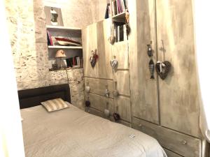 a bedroom with a bed and a wooden cabinet at Appartement de charme au coeur de Saint-Tropez in Saint-Tropez