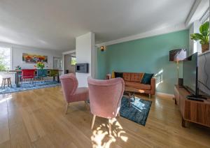 sala de estar con sofá, sillas y TV en Noorderhaecks Suites & Apartment, en 't Horntje